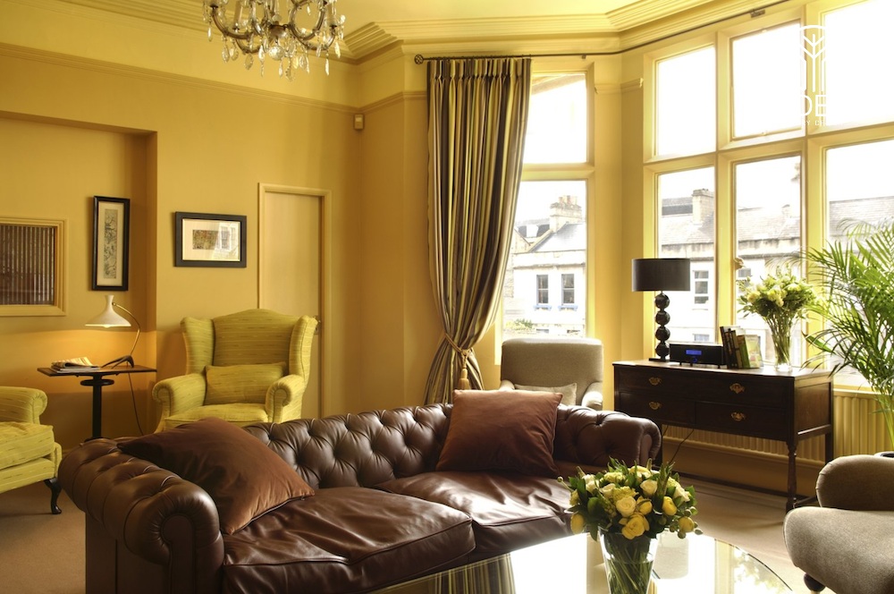 Màu vàng đồng của phòng khách kết hợp với sofa da giúp cho căn phòng mang nét cổ điển nhưng cũng sang trọng không kém
