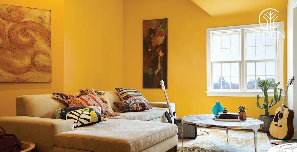 Phòng khách màu vàng cam phối hợp với cửa sổ trắng giúp căn phòng ấm áp, thoải mái