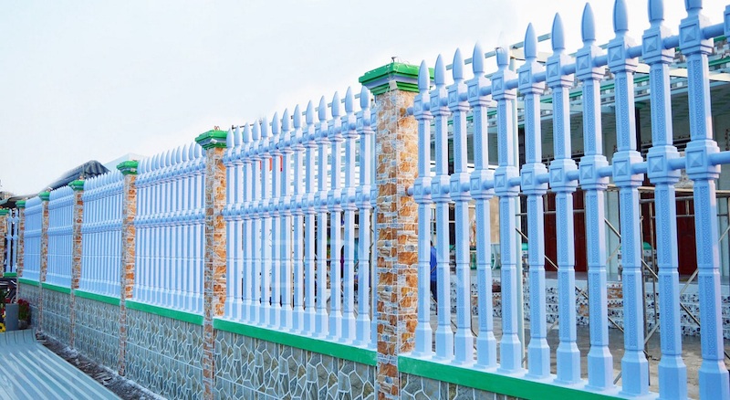 Hàng rào làm từ bằng bê tông kết hợp với kim loại sơn màu xanh nhã nhặn