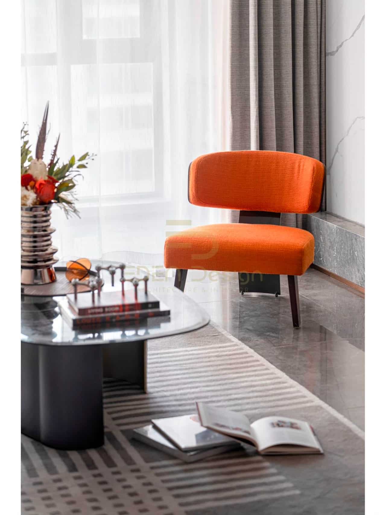 Một chiếc ghế màu cam tạo điểm nhấn ấn tượng cho phòng khách