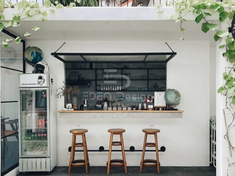 Thiết kế không gian quán cafe mang đi tối giản với tường sơn trắng và cây leo trang trí
